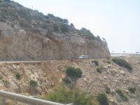 Važiuojantys automobiliai keliu esančiu kalne